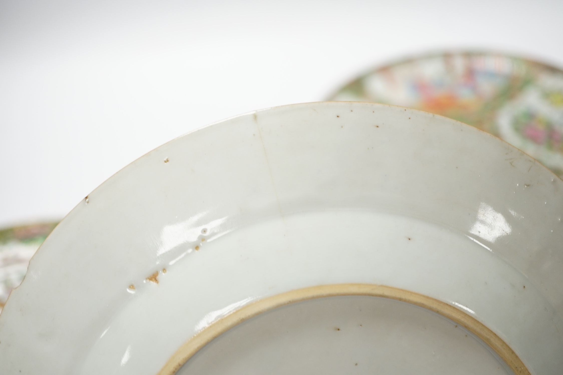 Two 19th century Chinese famille rose plates and an 18th century blue and white plate, 24cm in diameter